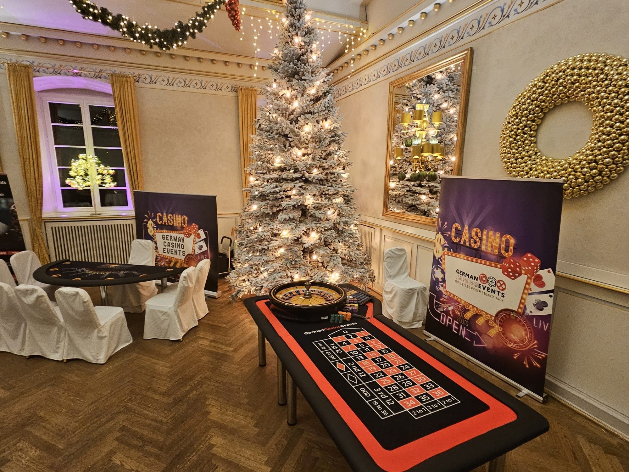 Roulette- und Blackjack-Tisch in einem festlich geschmückten Saal mit Weihnachtsbaum